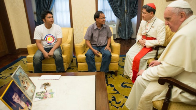 Pope Francis, right, and Cardinal Luis Antonio Tagle, second from right, meet the father of a young Catholic volunteer who was killed Saturday while helping organize his Mass in typhoon-hit Tacloban, in Manila, Philippines, Sunday, Jan. 18, 2015. The Vatican said Francis met Sunday for about 20 minutes with the girl's father at the Vatican Embassy in Manila. Police said Kristel Padasas, a volunteer with Catholic Relief Services, died when scaffolding fell on her. Witnesses said a sudden gust of wind toppled the structure, which served as platform for a large loudspeaker during the Mass. (AP Photo/L'Osservatore Romano, Pool)