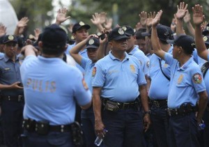 Filipino policemen raise their hands during security preparations for the visit of Pope Francis at the Cuneta Astrodome which they are using as temporary barracks in suburban Pasay, south of Manila, Philippines on Monday, Jan. 12, 2015. AP
