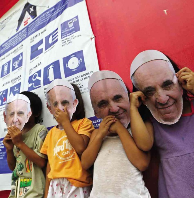 SECURITY preparations make it improbable for these children in Palo, Leyte province, wearing masks with Pope Francis’ face, to meet  Francis when he visits areas laid to waste by Supertyphoon “Yolanda.” RAFFY LERMA 