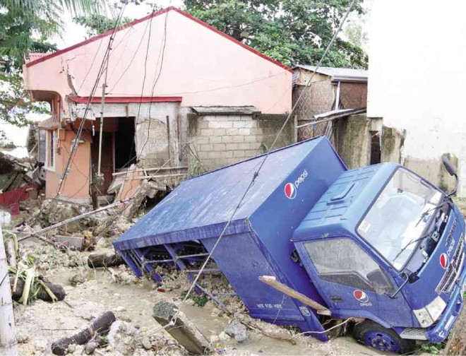 THE MAGNITUDE of the destruction left by Typhoon “Seniang” in Ronda town in Cebu province unraveled hours after floods swept nearly everything on its path, including this delivery van.  TONEE DESPOJO/CEBU DAILY NEWS 