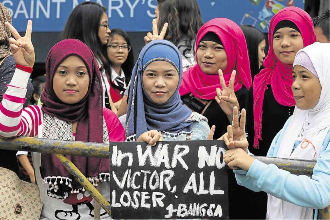  PEACE IS THE ANSWER  Members of several Moro groups make the peace sign with their fingers during a rally at the Golden Mosque in Quiapo, Manila, on Friday.   The Moro groups denounced war as a solution to the hostilities in Mindanao, and urged Congress to proceed with the hearings on the Bangsamoro Basic Law that has been on hold since the bloody Mamasapano clash of Jan. 25. JOAN BONDOC 