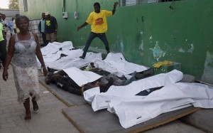 A woman walks away from bodies after failing to find a missing family member among them outside the morgue at the General Hospital in Port-au-Prince, Haiti, Tuesday, Feb. 17, 2015. At least 20 people were killed early Tuesday after a man on top of a musical group's Carnival float was electrocuted, setting off a panic in which dozens of people were trampled, witnesses and officials said. The woman said she would continue looking at a different hospital. (AP Photo/Dieu Nalio Chery)