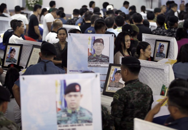 Mourners pay their last respects to the 44 police anti-terror commandos who perished last Sunday during the Philippines' biggest single-day combat loss in recent years, at Camp Bagong Diwa, Taguig City, on Friday, Jan. 30, 2015. In their last moments before Moro rebels mowed them down, the ill-fated commandos phoned and texted relatives and friends, pleading for help, asking them to tell their superiors that they had been surrounded and that they needed reinforcements.  AP PHOTO/BULLIT MARQUEZ 