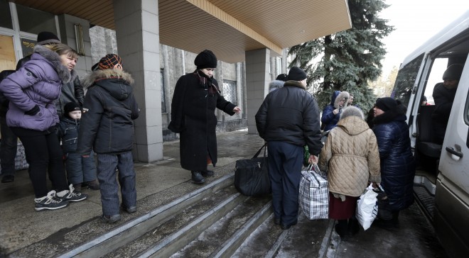 People carry their belongings as they walk to a bus to leave the town of Debaltseve, Ukraine, Saturday, Jan. 31, 2015. Fighting between government and Russian-backed separatist forces in eastern Ukraine has intensified in recent days as rebels seek to encircle the town of Debaltseve, which hosts a strategically important railway hub. (AP Photo/Petr David Josek)