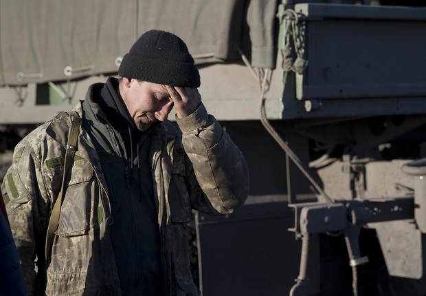 A Ukrainian serviceman touches his forehead outside Artemivsk, Ukraine, while pulling out of Debaltseve, Wednesday, Feb. 18, 2015. After weeks of relentless fighting, the embattled Ukrainian rail hub of Debaltseve fell Wednesday to Russia-backed separatists, who hoisted a flag in triumph over the town. The Ukrainian president confirmed that he had ordered troops to pull out and the rebels reported taking hundreds of soldiers captive. (AP Photo/Vadim Ghirda)