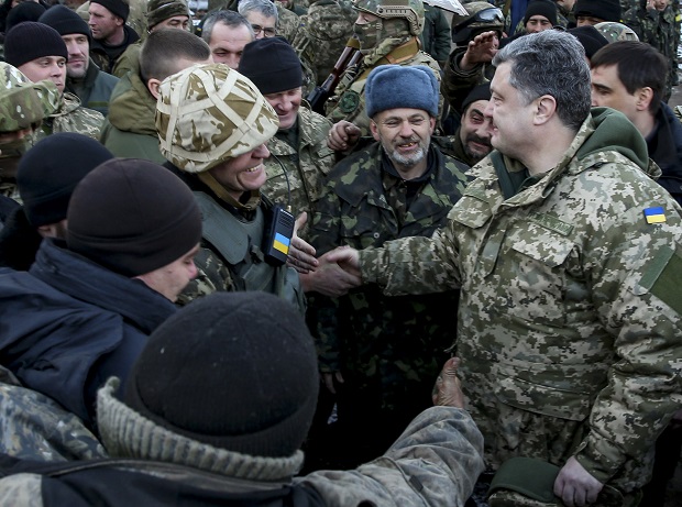 Ukrainian President Petro Poroshenko, right, shakes hands with Ukrainian servicemen in the town of Artemivsk, Ukraine, Wednesday, Feb. 18, 2015. Poroshenko traveled to eastern Ukraine to “shake the hands” of the soldiers leaving Debaltseve.  The Ukrainian president confirmed that he had ordered troops to pull out and the rebels reported taking hundreds of soldiers captive. (AP Photo/Mikhail Palinchak, Pool)