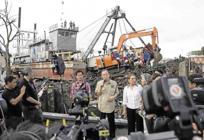  Ki-moon (center) talks to reporters in Tacloban City about a month after Supertyphoon “Yolanda” struck the Visayas. In the background is a dredge barge of the Department of Public Works and Highways that is still in the site. AP 
