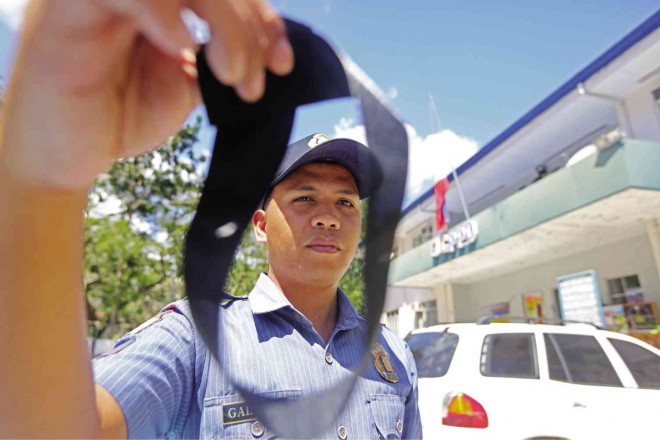 A POLICEMAN in Cebu City shows a black ribbon he would wear to join the mourning for 44 police commandos slain in Maguindanao. TONEE DESPOJO/CEBU DAILY NEWS