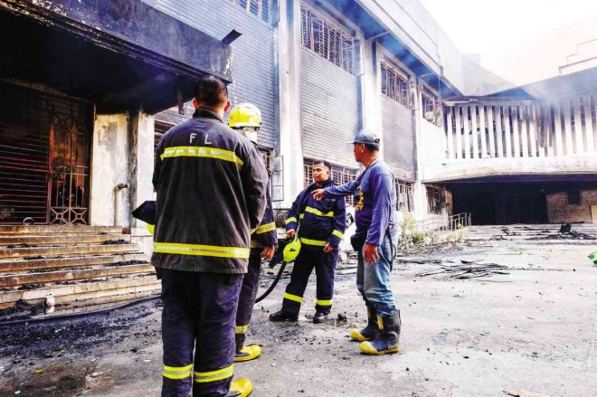 Firemen gather outside the Hall of Justice building in Cagayan de Oro, which was hit by a fire that lasted from Friday night to Saturday dawn. BOBBY LAGSA/INQUIRER MINDANAO