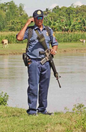A POLICEMAN takes a call on his mobile phone in the village of Tukanalipao, Mamasapano town, Maguindanao province, where 44 policemen were killed by Moro guerrillas. JEOFFREY MAITEM/INQUIRER MINDANAO
