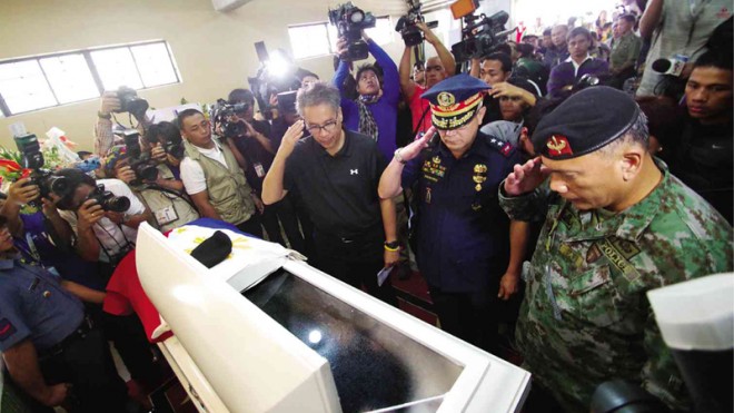 FINAL FAREWELL TO BRAVE TROOPERS  Interior Secretary Mar Roxas, Chief Supt. Carmelo Valmoria and Chief Supt. Noli Taliño, acting director of the Special Action Force, salute the late PO2 Peterson Carap at his wake in the Church of the Resurrection in Baguio City. Carap was one of the 44 police commandos killed in Maguindanao province in clashes with Moro rebels on Jan. 25.  RICHARD BALONGLONG/INQUIRER NORTHERN LUZON