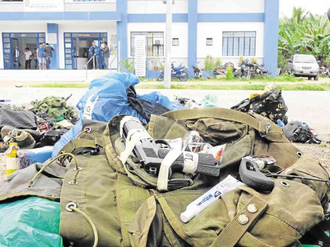 BACKPACKS containing personal belongings and handguns believed left behind by communist rebels who attempted to overrun the Mati City police station are recovered by police on Tuesday. FRINSTON LIM/INQUIRER MINDANAO