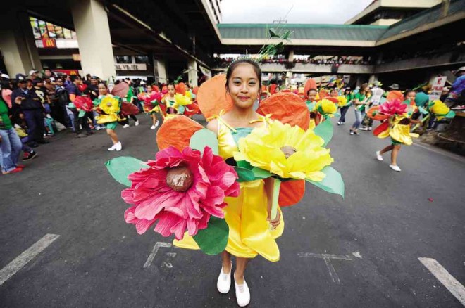 BAGUIO pupils, dressed in bright dresses, dance along downtown Baguio streets during the opening parade of this year’s Baguio Flower Festival on  Sunday. This is the 20th staging of the event designed to draw back tourists to Baguio, which rebuilt from the devastation of the 1990 Luzon earthquake. 