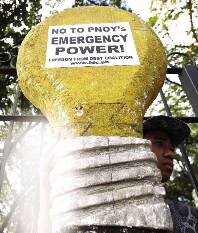 PROTESTERS at a rally in Quezon City carry placards designed to look like light bulbs to demand a rejection by Congress of President Aquino’s request for emergency powers to deal with a projected energy crisis. LYN RILLON