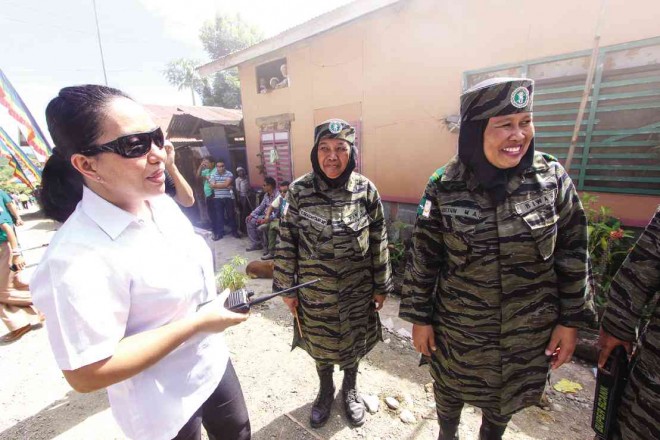 IN ONE of the biggest successfully coordinated efforts of the government and the Moro Islamic Liberation Front (MILF), an unidentified member of the Presidential Security Group exchanged banter with female members of the MILF as both government and MILF forces helped secure an area near the MILF’s Camp Darapanan that was visited by President Aquino in February 2013. KARLOS MANLUPIG