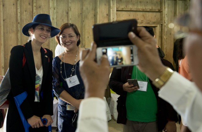 French actress Marion Cotillard (L) poses for pictures as part of a visit with French President Francois Hollande in Guiuan, Eastern Samar province on February 27, 2015. Hollande on February 27 visited a remote Philippine town devastated by one of the world's strongest typhoons, seeking to sound a global alarm on climate change ahead of a crucial UN summit. AFP 