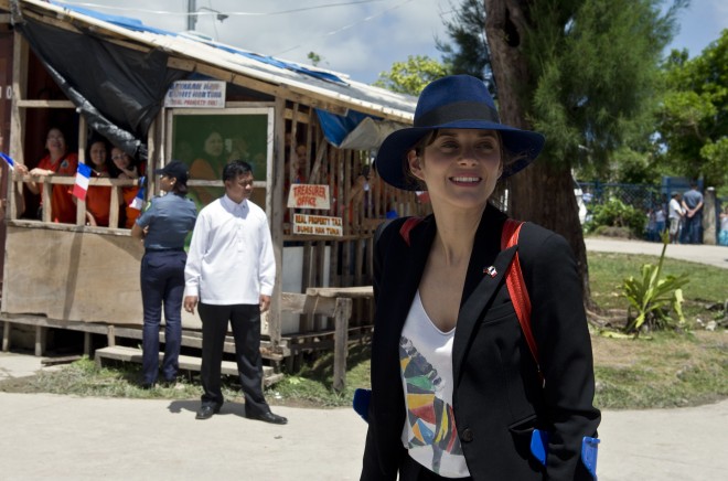 French actress Marion Cotillard smiles as she walks along a street as part of a visit by French president Francois Hollande in Guiuan, Eastern Samar province on February 27, 2015. Hollande on February 27 visited a remote Philippine town devastated by one of the world's strongest typhoons, seeking to sound a global alarm on climate change ahead of a crucial UN summit. AFP 