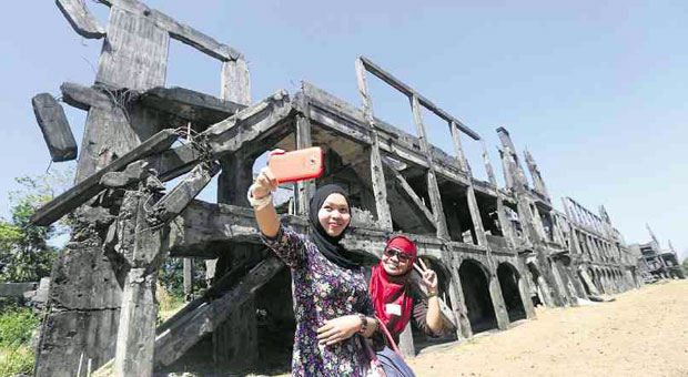 IT BEGAN WITH MARCOS MILITARY PLOT  Two Muslim women take a selfie in front of the Corregidor ruins in Bataan, which now sport a new marker on the Jabidah massacre 47 years ago. Soldiers shot Muslim recruits who tried to escape Corregidor where they were being trained for a Sabah invasion. When the Muslims discovered the plot, they rebelled but were executed. Only one survived. The number of deaths has remained unknown.  MARIANNE BERMUDEZ