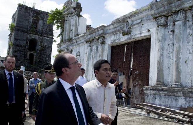 French President Francois Hollande (L) and Guiuan mayor Christopher Sheen (R) visit a church destroyed by a typhoon in 2013 in Guiuan on February 27, 2015. Hollande on February 27 visited a remote Philippine town devastated by one of the world's strongest typhoons, seeking to sound a global alarm on climate change ahead of a crucial UN summit. AFP
