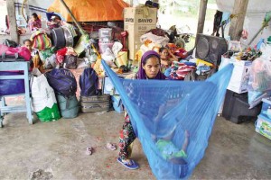DISRUPTED LIVES  Evacuees hurdle a difficult life, including hunger, while living in temporary shelters following their displacement due to the all-out military offensive in Maguindanao province.  Dennis Jay Santos/ Inquirer Mindanao 