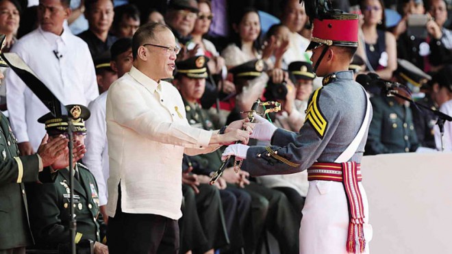 TOP GRAD  President Aquino presents the Presidential Saber to Cadet First Class Arwi C. Martinez, valedictorian of the PMA Sinaglahi Class, during graduation rites in Baguio City.  GRIG C. MONTEGRANDE