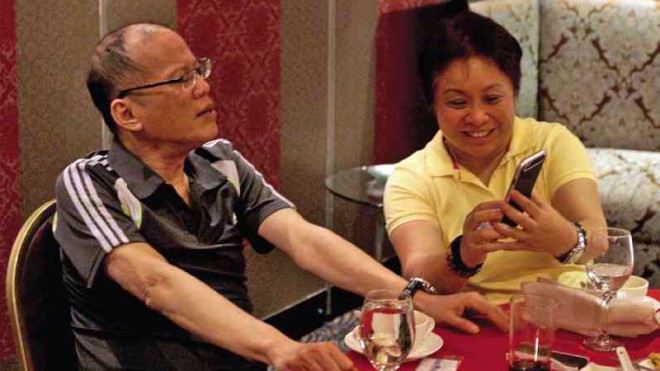 PRIVATE DINNER Revenue Commissioner Kim Henares shares a smartphone message with President Aquino during a dinner with friends in a restaurant in Quezon City. RICHARD A. REYES