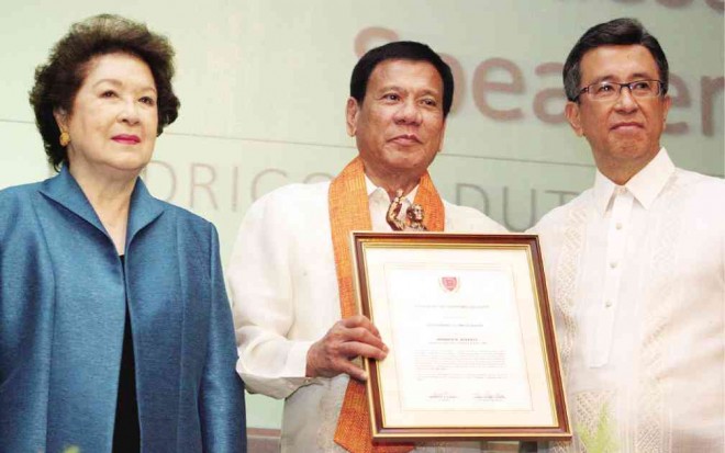 DUTERTE is presented the framed citation by LPU chair Lorna P. Laurel and Manila campus president Roberto Laurel.