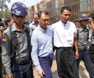 V Gastro bar owner Tun Thurein, second from left, and employee Htut Ko Ko Lwin, second from right, are escorted by Myanmar police officers as they arrive for their trial at a township court Tuesday, March 17, 2015, in Yangon, Myanmar. AP