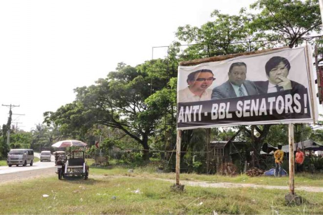 AS WAR continues between the government and the Bangsamoro Islamic Freedom Fighters, residents of Sultan Kudarat town in Maguindanao province, which has become home to hundreds of evacuees, put up tarpaulins showing who to them are enemies of peace—the three senators blocking the passage of the proposed Bangsamoro Basic Law. KENNY NODALO/CONTRIBUTOR