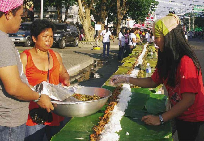 Laoag residents and guests partook of a 5-kilometer feast on Feb. 27 offered in what the city believes is the longest boodle fight that could make the Guinness World Record. LEILANIE ADRIANO/ INQUIRER NORTHERN LUZON