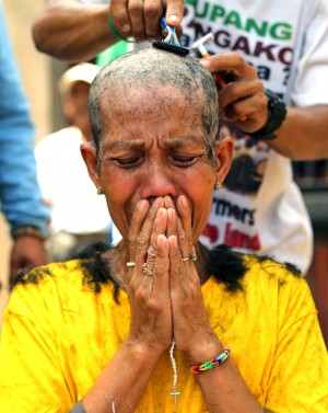 A woman has her heads shaved during a rally at the gates of the House of Representatives in Quezon City on Monday, March 9, 2015.  AP PHOTO/AARON FAVILA