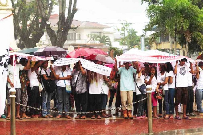 Land reform beneficiaries brave the rain at a rally in front of the municipal hall of Sariaya, Quezon province, to press for a repeal of what they said was an antiland reform zoning ordinance. PHOTO FROM SARIAYA LGU FACEBOOK PAGE 