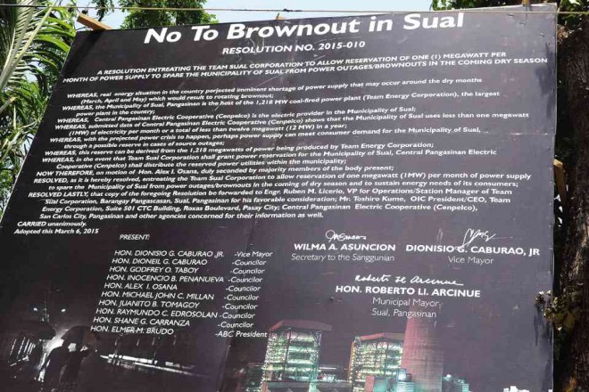 A billboard relaying Sual’s plea for direct electricity connection to protect the town from brownouts rises in the town proper. 