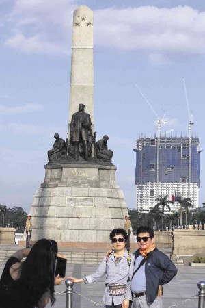 Torre de Manila is impossible to miss in the background as tourists have their picture taken at the Rizal Monument.  Niño Jesus Orbeta
