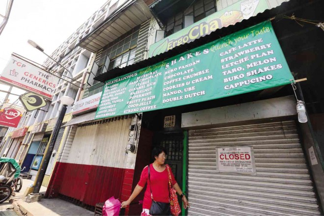 MILAGROS Valenzuela, Manila sanitation officer for Sampaloc district, passes by the now-closed ErgoCha tea shop as she led the inspection of other food establishments on Bustillos Street on Saturday. Joan bondoc 