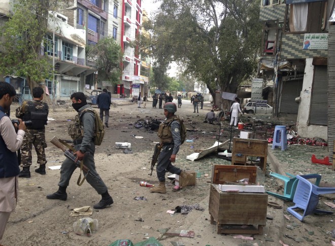 Afghan security forces members inspect the site of a suicide attack near a new Kabul Bank in Jalalabad, east of Kabul, Afghanistan, Saturday, April, 18, 2015. A security official says that at least 22 people have been killed after a suicide bomber attacked a bank branch in eastern Afghanistan. AP 