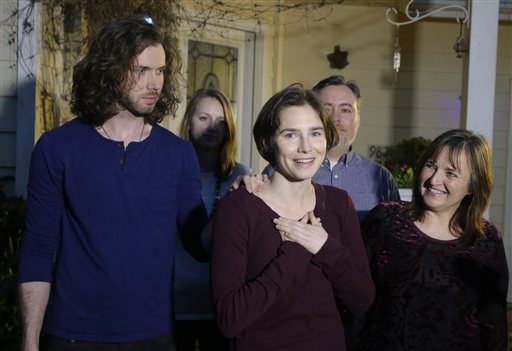 Amanda Knox, center, stands with her mother, Edda Mellas, right, and her fiance, Colin Sutherland, left, as she talks to the media outside Mellas' home, Friday, March 27, 2015, in Seattle. AP