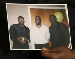 In this April 8, 2015 photo, Anthony Scott holds an undated photo that shows himself, center, and his brothers Walter Scott, left, and Rodney Scott, right, as he talks about Walter at his home near North Charleston, S.C. Walter Scott was killed by a North Charleston police officer after a traffic stop on Saturday, April 4, 2015. The officer, Michael Thomas Slager, has been fired and charged with murder. AP