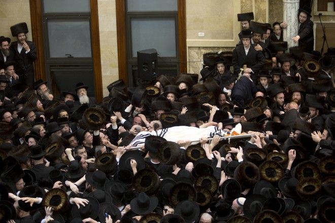 Ultra Orthodox Jews ferry the body of a prominent Hasidic Rabbi Shmuel Halevi Wosner during his funeral in Bnei Brak, Israel, Sunday, April 5, 2015. A man was crushed to death in a stampede of surging crowd during the funeral, a police spokesman said. (AP Photo/Moti Milrod)