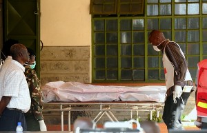A funeral home worker pushes the body of a victim of the Garissa University attack, at a funeral home, in Nairobi, Kenya, Friday, April  3, 2015. The militants who slaughtered 147 people in a Kenyan school appeared to have planned extensively, even targeting a site where Christians had gone to pray, a survivor said Friday. AP