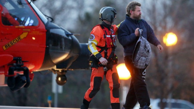 Louis Jordan, right, walks from the Coast Guard helicopter to the Sentara Norfolk General Hospital in Norfolk, Va., after being found off the North Carolina coast, Thursday, April 2, 2015. His family says he sailed out of a marina in Conway, S.C., on Jan. 23, and hadn't been heard from since. (AP Photo/The Virginian-Pilot, Steve Earley)