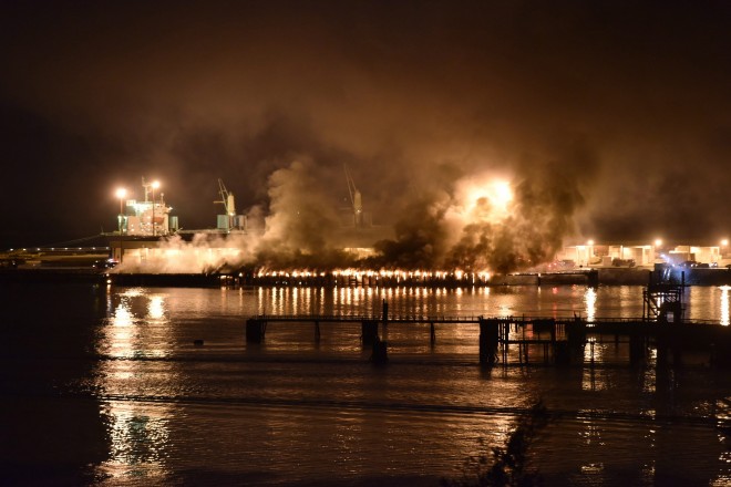 A significant amount of dark and smelly smoke from a fire at a deep-water port terminal billowed over the town of Squamish, British Columbia, Thursday night April 16, 2015, forcing municipal officials to ask residents to stay indoors. (The Canadian Press, Silvester Law via AP)