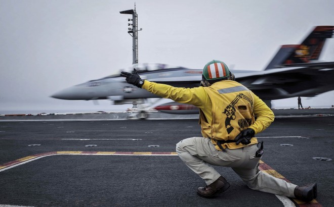 In this Wednesday, April 15, 2015 image released by the U.S. Navy, a shooter launches an F/A-18F Super Hornet, assigned to the Red Rippers of Strike Fighter Attack Squadron 11, off the flight deck aboard Nimitz-class aircraft carrier USS Theodore Roosevelt in the Fifth Fleet area of operations. he U.S. Navy has dispatched USS Theodore Roosevelt toward the waters off Yemen to join other American ships prepared to intercept any Iranian vessels carrying weapons to Houthi rebels, U.S. officials said on Monday. (Mass Communication Specialist Seaman Anna Van Nuys/U.S. Navy Media Content Services via AP)