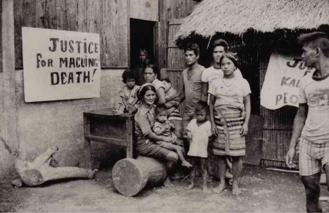 SAMUN, (seated, with child on lap), wife of Macli-ing Dulag, and her children put up streamers in their house in the village of Bugnay in Tinglayan to call for justice over the murder of the Kalinga elder.  MA. CERES DOYO 
