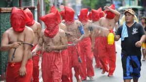 A man (R) sprays penitents with water to cool them down as they flagellate themselves as part of Lenten observance in Manila on April 2, 2015. The dominant Roman Catholic church does not condone flagellation and other extreme acts of penitence including gory Good Friday reenactments of the crucifixion of Jesus Christ, but devout Catholics say it is a means of atoning for their sins and to implore God to spare them and other members of their families from illness or bad luck. AFP PHOTO/TED ALJIBE 