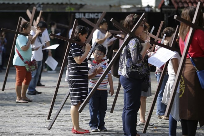 Filipino devotees pause to pray as they carry wooden crosses while doing the Stations of the Cross at the Philippine Center of Saint Pio of Pietrelcina on Wednesday, April 1, 2015 in suburban Quezon city, east of Manila, Philippines. Devotees practice different religious rites during the Holy Week in this predominantly Roman Catholic country. AP FILE PHOTO