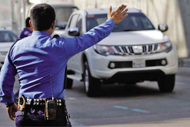 AN LTO ENFORCER flags down a pickup without a license plate on Edsa in Cubao, Quezon City, on the first day of the implementation of the agency’s “no plate, no travel” policy. Violators face up to P10,000 in fines on top of the impounding of their vehicles. LEO M. SABANGAN II
