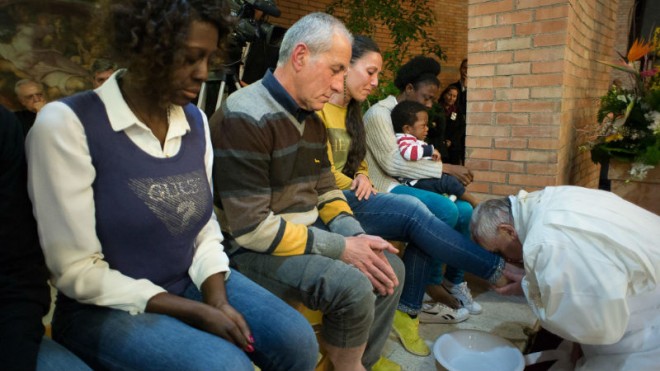 Pope Francis, right, kisses the foot of a woman at Rebibbia prison in Rome, Thursday, April 2, 2015. Pope Francis washed the feet of 12 inmates and a baby at Rome's main prison Thursday in a pre-Easter ritual meant to show his willingness to serve. He asked them to pray that he, too, might be cleansed of his "filth." (AP Photo/L'Osservatore Romano, Pool)