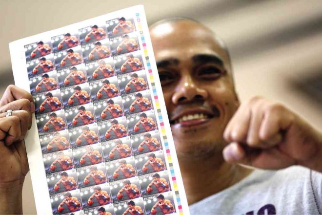 DON MAURO M. Pabor Jr. shows off the special edition Pacquiao stamps he bought from the PhilPost office in Manila. The limited edition stamps are selling like hotcakes.  NIÑO JESUS ORBETA