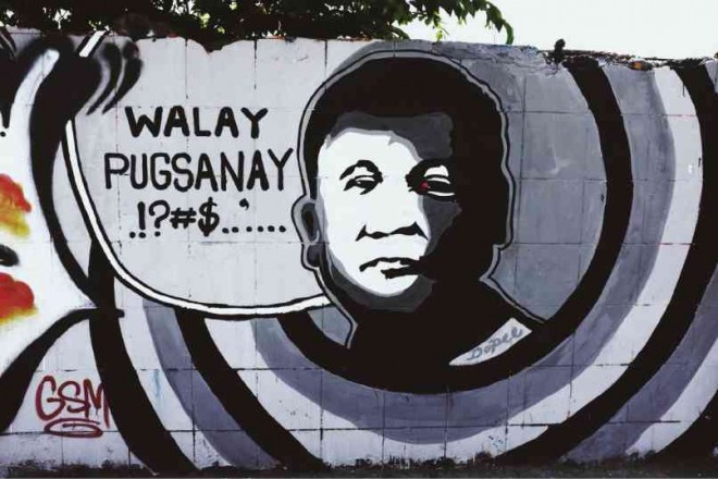 WALL MESSAGE “Walay pusganay” (Don’t force me) reads a message on a wall in Davao City with a sketch of Mayor Rodrigo Duterte in what seems to be an attempt to portray the tough-talking politician’s statement that he should not be forced to run for President in 2016. KARLOS MANLUPIG/INQUIRER MINDANAO 
